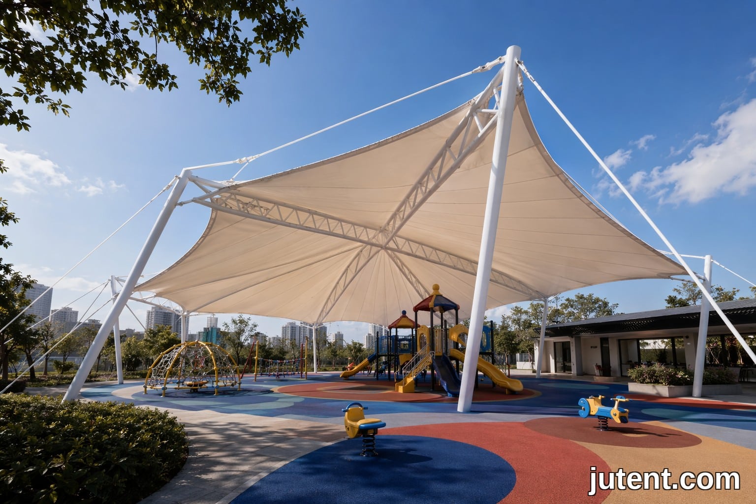 Large commercial tensile membrane shade structure covering a colorful playground with steel supports and fabric canopy