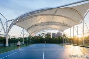 Pemandangan udara kanopi membran tegangan PVDF putih meliputi tiga gelanggang tenis tanpa tiang perantaraan, menyediakan teduhan bebas silau di Manila