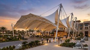 Hotel tensile canopy with PTFE membrane shading outdoor pool area under intense Middle East sun and extreme heat