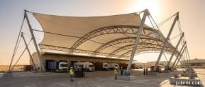 Jutent heat-resistant tensile membrane canopy over loading bay in Gulf region with trucks and extreme sun
