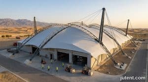Large white tensile fabric warehouse canopy shading logistics hub in desert heat with steel structure and UV protection