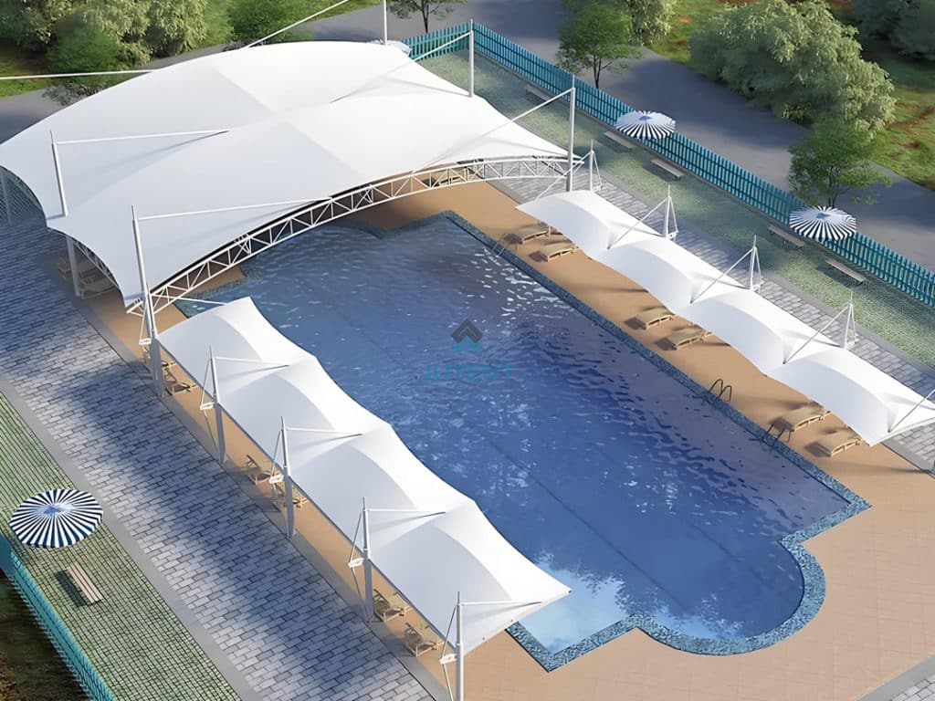 Resort poolside lounge protected by white tensile fabric canopy