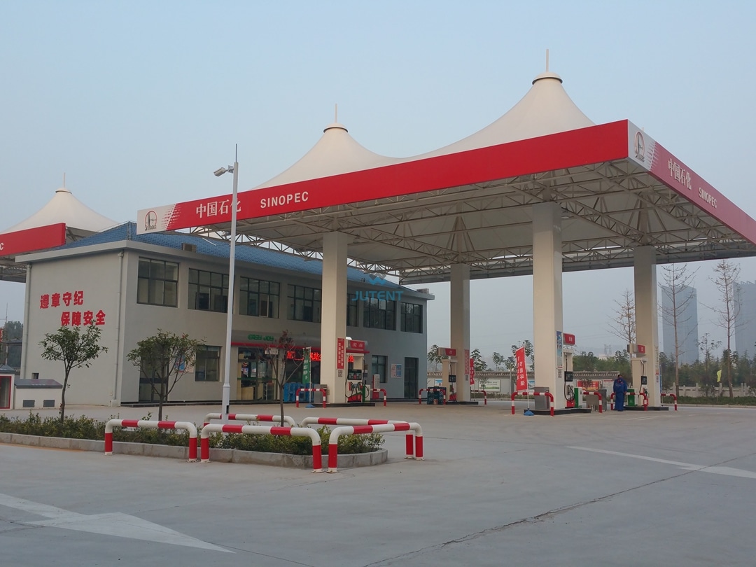 Gas station tensile canopy g02 Illuminated large span gas station tensile membrane canopy with integrated LED lighting system at night.