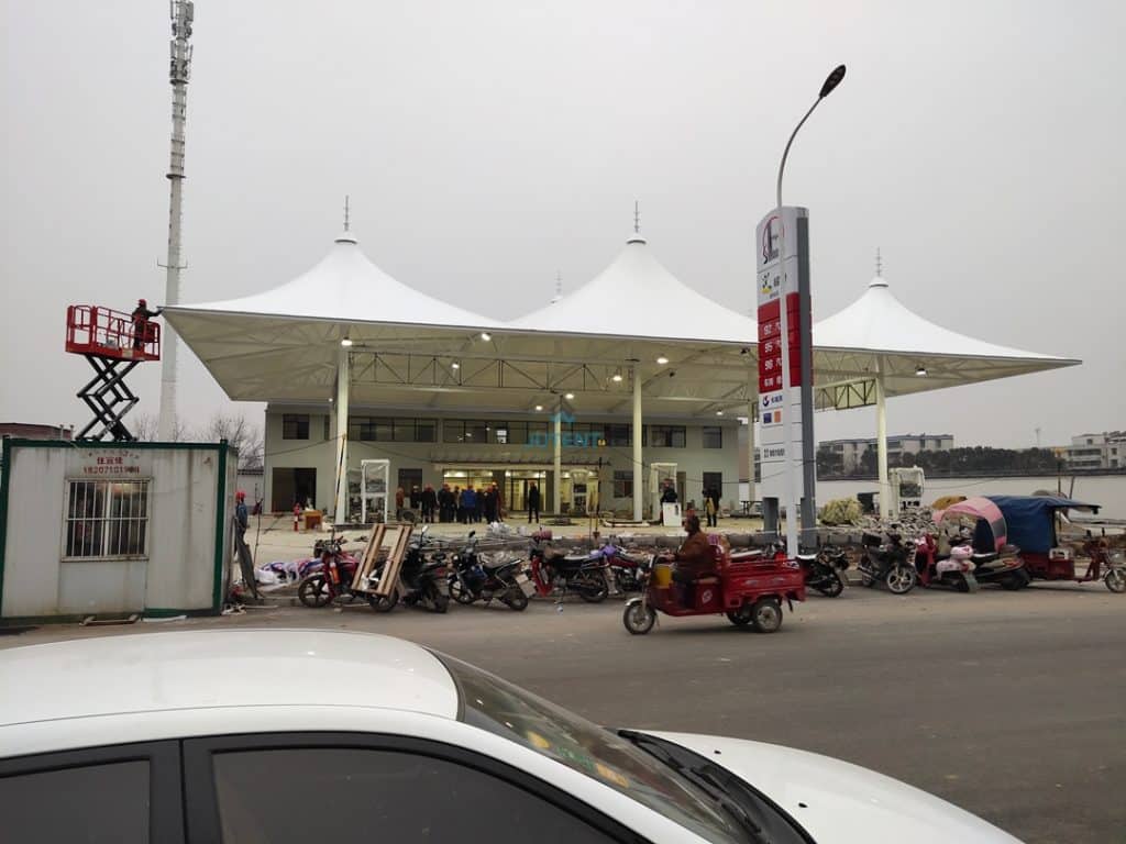 Efficient drainage system integrated into large span tensile membrane canopy for gas station rainwater management.