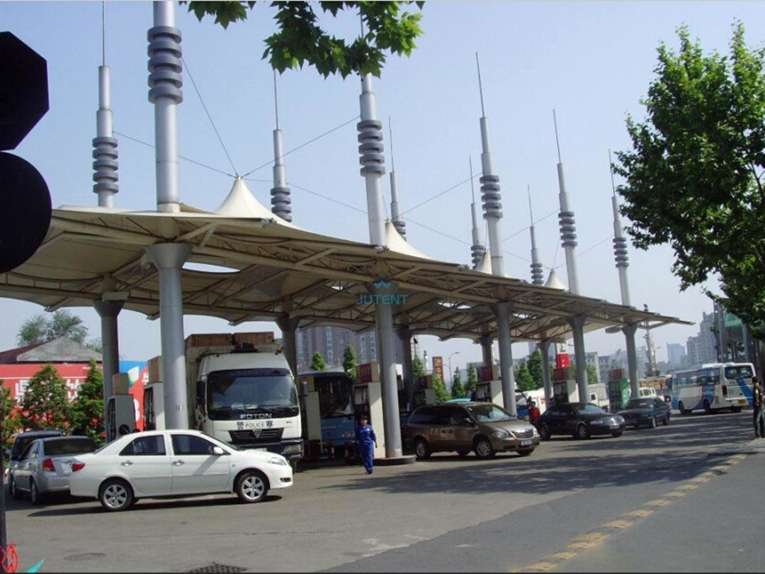 Gas station tensile canopy g08 Steel frame structure supporting large span tensile membrane canopy at fuel station forecourt.